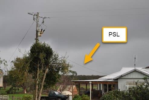 A photograph of a private service line on a suburban or rural street. Text with an arrow overlays a small section of the right side of the photograph, noting the private service line, which is a single wire connecting a residence to a power pole.