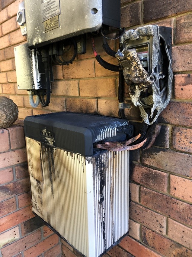 A photograph of a solar battery that has caught fire, with burn marks and melted components.