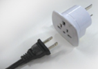 A photograph of a travel charger and overseas electrical plug.